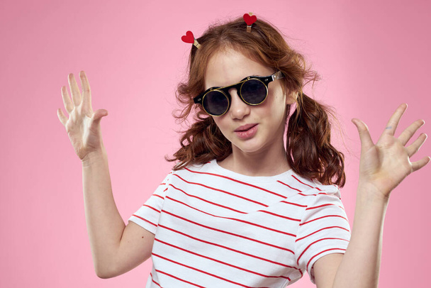 Veselá dívka s copánky sluneční brýle pruhované tričko životní styl růžové pozadí - Fotografie, Obrázek