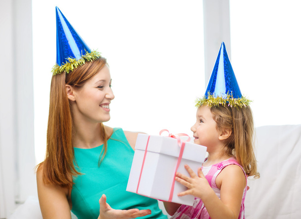 Mother and daughter in blue hats with favor horns - Photo, image