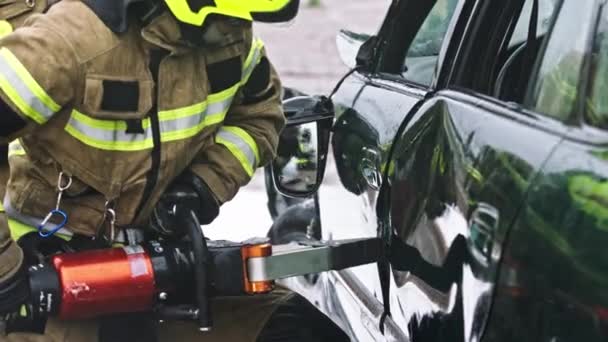 Firefighter using jaws of life to extricate trapped victim from the car - Footage, Video