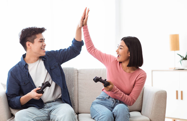 Asian Boyfriend And Girlfriend Giving High-Five Winning Videogame At Home - Photo, Image