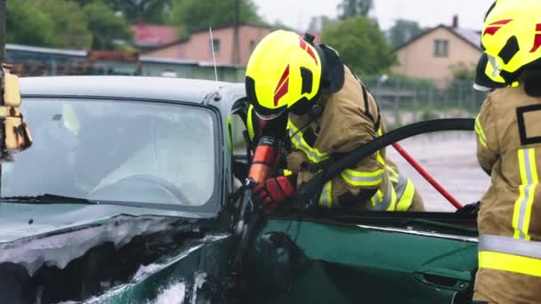 Firefighter using jaws of life to extricate trapped victim from the car - Footage, Video