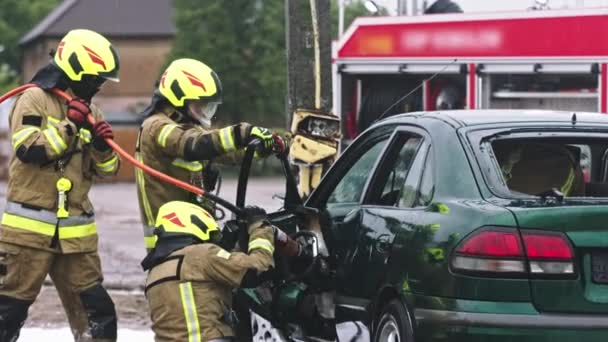 A tűzoltók az élet állkapcsait használják, hogy kiszabadítsák a csapdába esett áldozatot az autóból. - Felvétel, videó