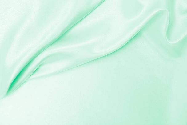 Smooth elegant green silk or satin luxury cloth texture can use as abstract background. Luxurious background design - Photo, image