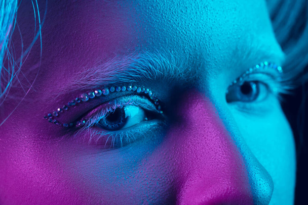Portrait of beautiful albino girl isolated on dark studio background in neon light - Zdjęcie, obraz