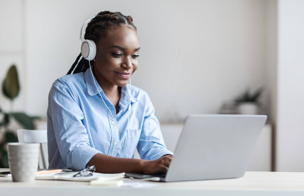 Millennial Black Female Employee Working With Laptop And Listening Music In Office - Foto, immagini