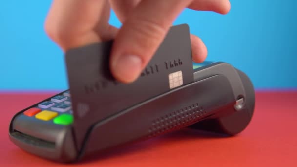Kontaktlose Zahlung per Terminal, schwarze Kreditkarte zum Bezahlen der Rechnung aus nächster Nähe verwenden - Filmmaterial, Video