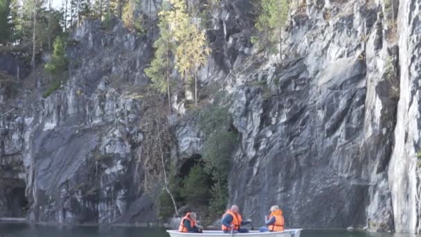 Uma família monta um barco sobre um lago em um belo parque na Carélia - Filmagem, Vídeo