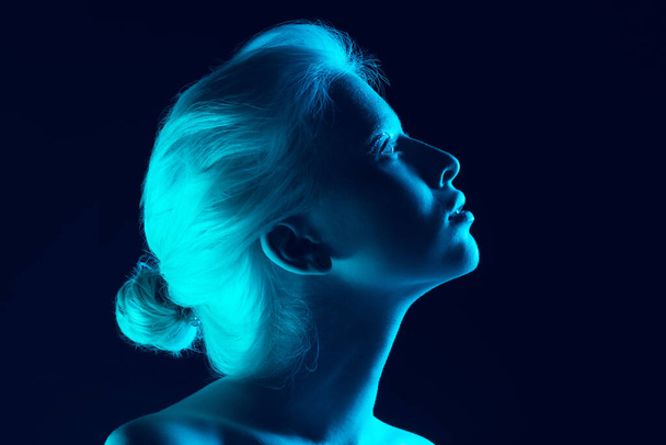 Portrait of beautiful albino girl isolated on dark studio background in neon light - Foto, afbeelding