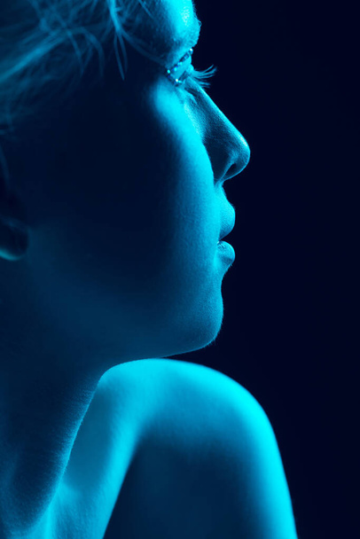 Portrait of beautiful albino girl isolated on dark studio background in neon light - Φωτογραφία, εικόνα