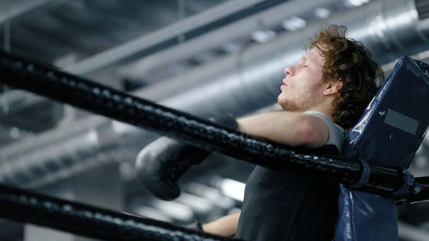 Λυπηρό kickboxer χάνει αγώνα στο γυμναστήριο. Αναστατωμένος αθλητής στέκεται στο ρινγκ - Φωτογραφία, εικόνα