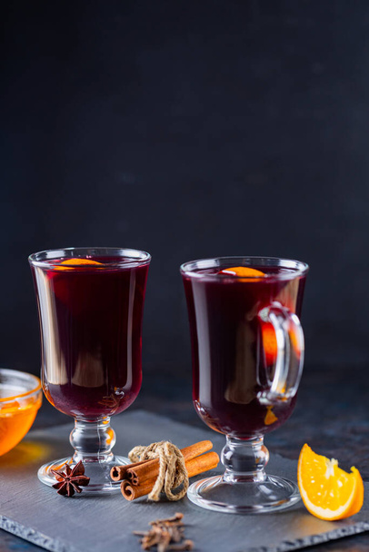 Mulled wine on a slate board. Two glasses of hot mulled wine and ingredients. Christmas hot drink with wine and honey - Foto, Bild