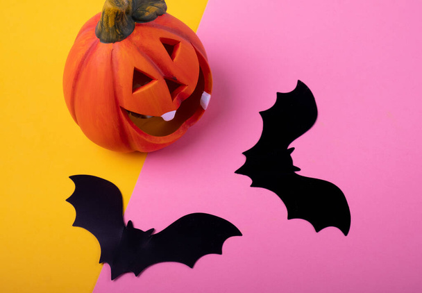 Two bats and a pumpkin on a bright background. Halloween background. - Foto, Imagem