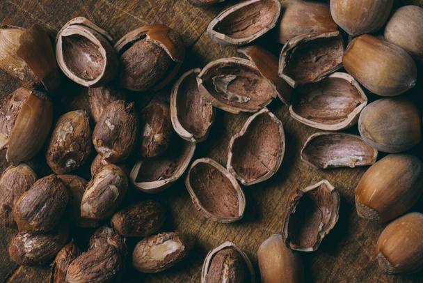 Whole nuts, shelled nuts and shells. Corylus avellana. Macro photo, close up, on wooden table. Top view. - Valokuva, kuva