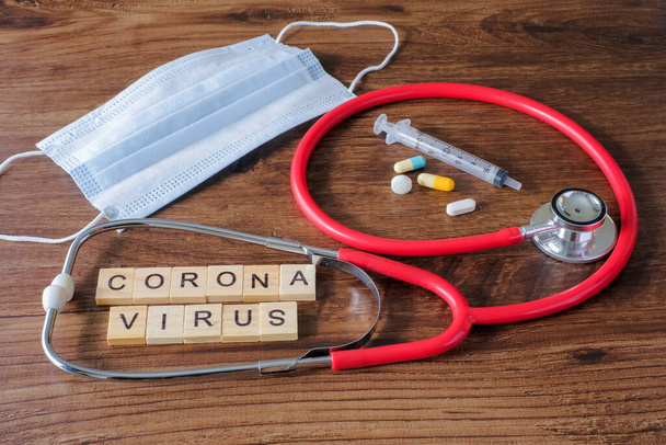 テキストフレーズ医療機器と木製の背景にコロナウイルス。新規コロナウイルス2019-nCoV中東呼吸器症候群コロナウイルス. - 写真・画像