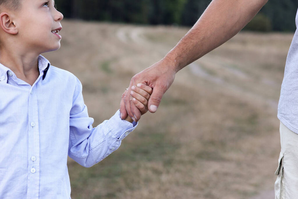 the happy parent holds the hand of a small child - Valokuva, kuva