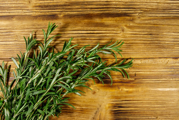 Fresh rosemary herbs on a wooden table. Top view - 写真・画像