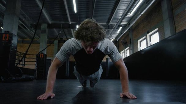 Caça exausta a suar no centro de fitness. Kickboxer fazendo flexões no ginásio - Foto, Imagem
