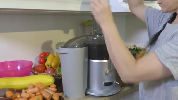 Kobieta zrobić sok warzywny w sokowirówce - Materiał filmowy, wideo