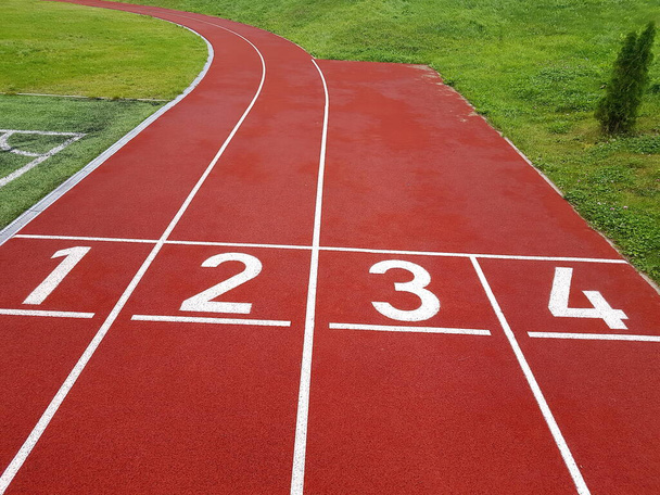 Red running racetrack on the stadium. Red running tracks in the stadium. Empty sport stadium. Starting Line of Track Running Lanes in  stadium - Photo, Image