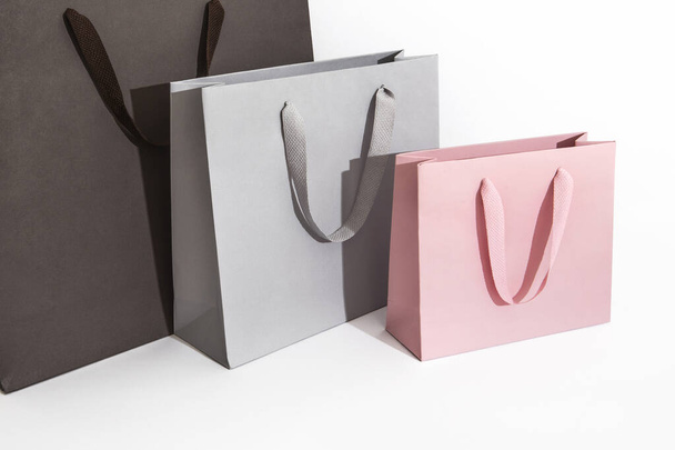 velké tmavé a světle šedé střední a růžové malé papírové tašky a nakupující - Fotografie, Obrázek
