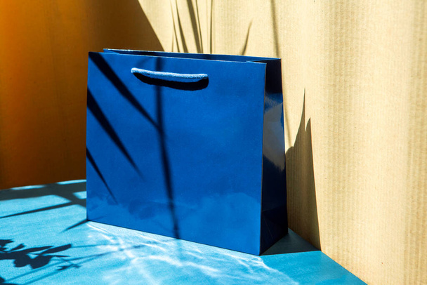 niebieski luksusowy papierowy worek pod słońcem z cieniami - Zdjęcie, obraz