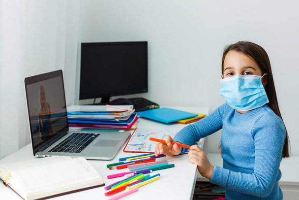 Jong blank meisje studeert thuis met online cursussen tijdens de coronavirus quarantaine. Concept afstandsonderwijs - Foto, afbeelding