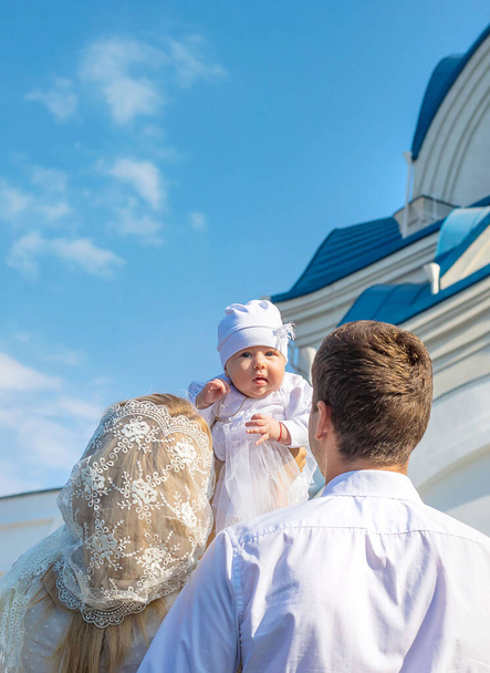 Мама и папа держат ребенка в церкви. Выборочный фокус. Люди. - Фото, изображение