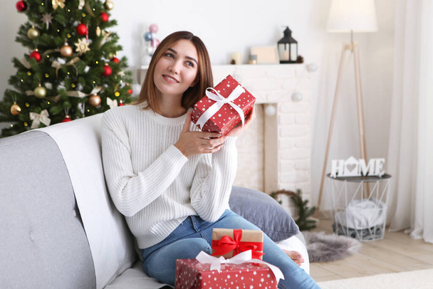 gyönyörű fiatal nő egy karácsonyi lakásban ajándékokkal. A szöveg helye, ünnepi háttér - Fotó, kép