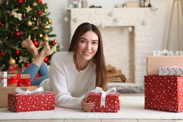 belle jeune femme dans un intérieur de Noël avec des cadeaux. Lieu de texte, fond festif - Photo, image
