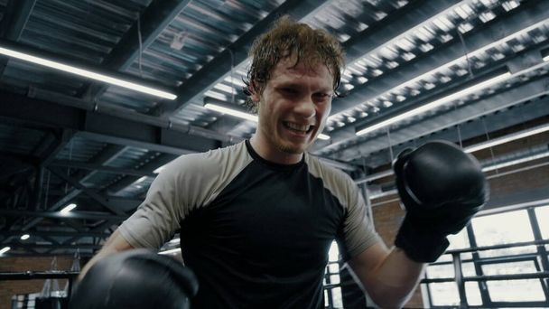 Anxious fighter exercising in box at gym. Sportsman making progress on ring - Fotó, kép