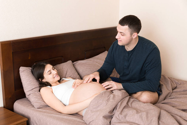 Hamile bir kadın sabah kocasıyla yatakta.. - Fotoğraf, Görsel