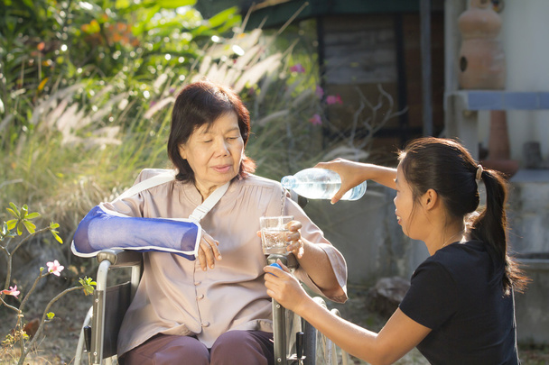Giovane asiatico sta prendendo cura della donna anziana
 - Foto, immagini