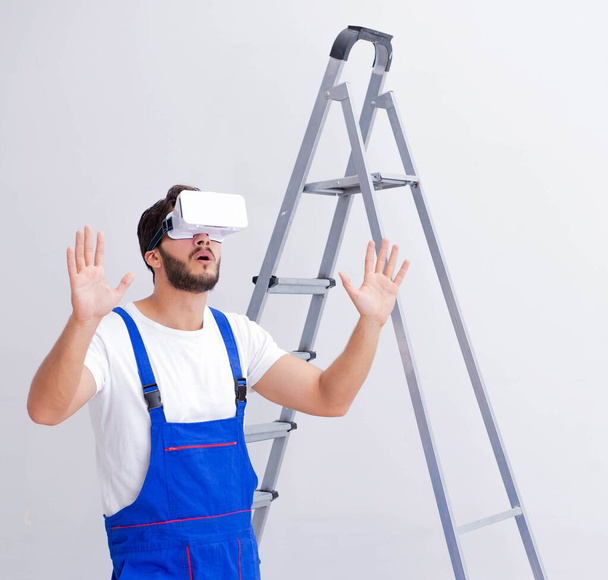 Man with VR glasses gluing wallpaper - Photo, Image