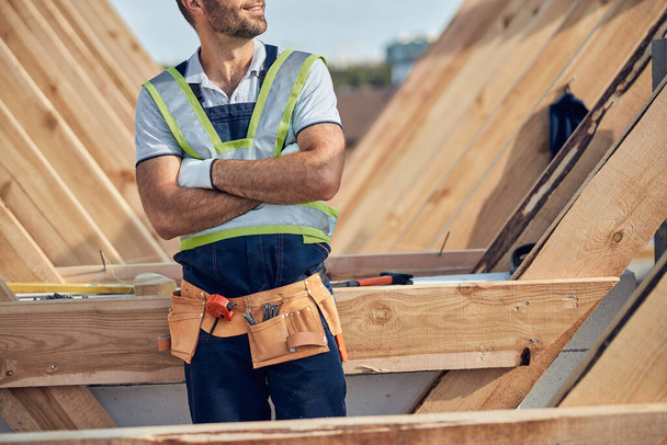 Proud builder in uniform posing with arms crossed - Photo, Image