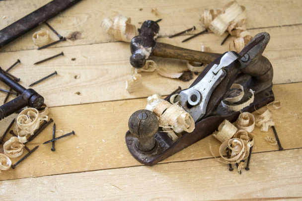 Carpenter työkalut lähikuva valokuva. Vintage käsisaha, puristin, lentokone työkalu ja puulastujen ylhäältä.  - Valokuva, kuva