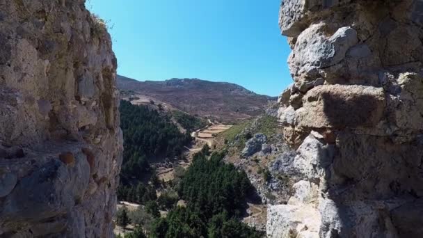 Mirando a través de un hueco en la pared de las ruinas del castillo de Paleo Pili un sitio histórico en la isla de Kos en Grecia. - Metraje, vídeo