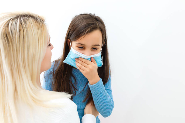 感染症に対する保護、コロナウイルスの概念。母親と娘の感染を防ぐために衛生マスクを着用し、インフルエンザなどの呼吸器疾患、。ウイルス感染のリスクを最小限に抑える. - 写真・画像