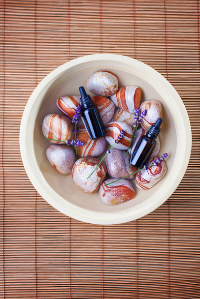 miska s kameny voda a levandulový esenciální olej - kosmetické ošetření - Fotografie, Obrázek