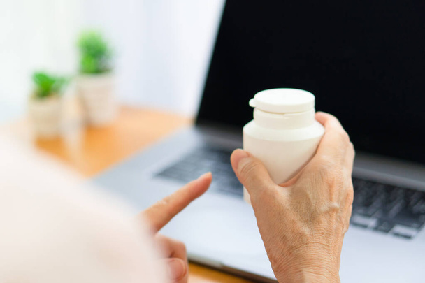 senior woman show bottle of medication to doctor who give consultation online. telemedicine and healthcare concept (focus at right hand) - Photo, Image
