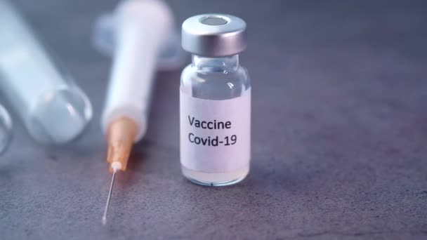 Primer plano de la vacuna contra el coronavirus y la jeringa sobre fondo negro - Imágenes, Vídeo