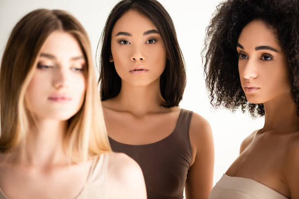 african american and asian women near blonde model on blurred foreground isolated on white - Φωτογραφία, εικόνα