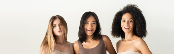 junge interrassische Frauen lachen isoliert auf weißem Banner - Foto, Bild