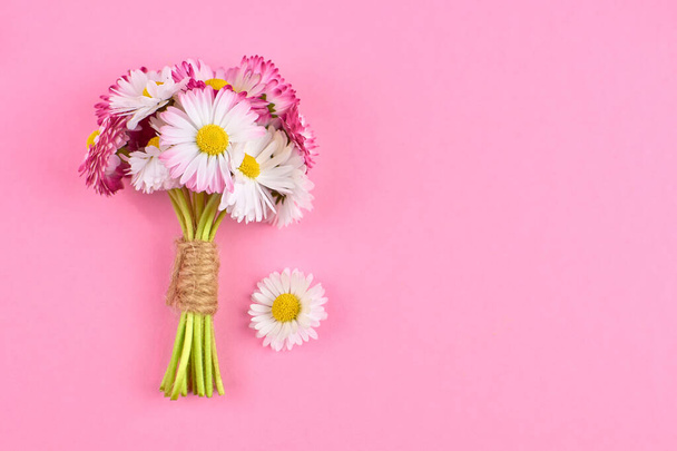 Daisy flowers spring bouquet on pink background. - Фото, изображение