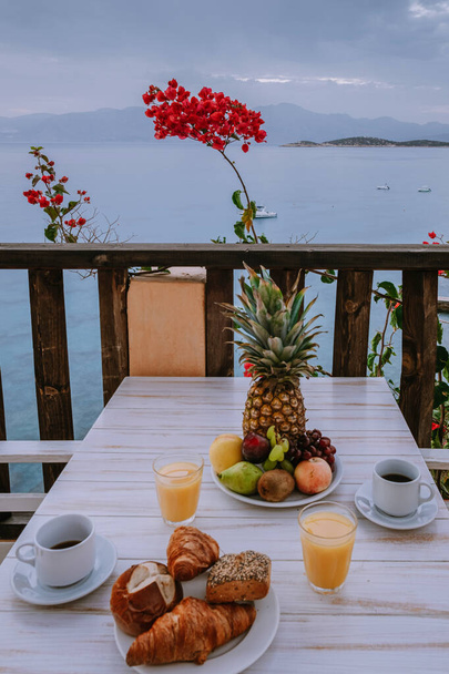 Tisch und Stühle mit Frühstück bei Sonnenaufgang am meditativen Meer in Griechenland - Foto, Bild