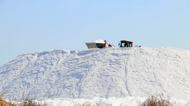 Huelva, Ισπανία - 1 Οκτωβρίου 2020: Εκσκαφέας που εργάζεται σε μια τεράστια στοίβα αλάτι σε αλυκές στο Marismas del Odiel. Θαλάσσιο αλάτι παραγόμενο με εξάτμιση θαλασσινού νερού. - Πλάνα, βίντεο