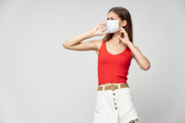 Woman in protective mask against coronavirus posing in studio. - Фото, зображення