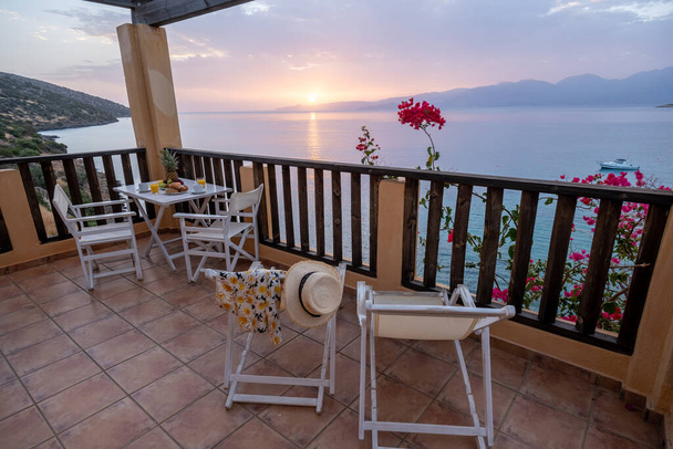 Tisch und Stühle mit Frühstück bei Sonnenaufgang am meditativen Meer in Griechenland - Foto, Bild
