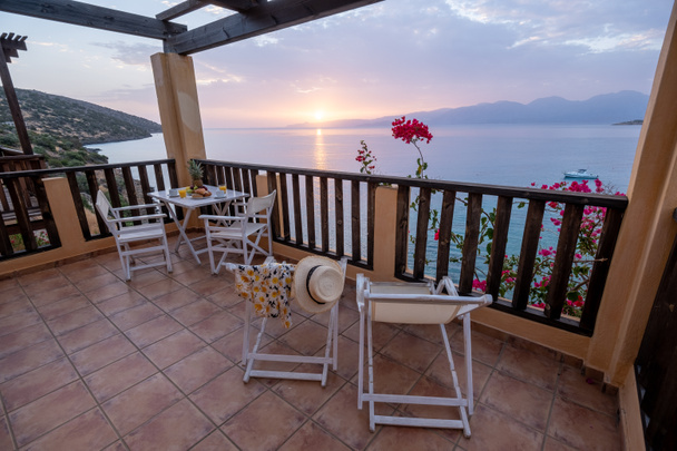 stół i krzesła ze śniadaniem podczas wschodu słońca nad morzem meditarnym w Grecji - Zdjęcie, obraz