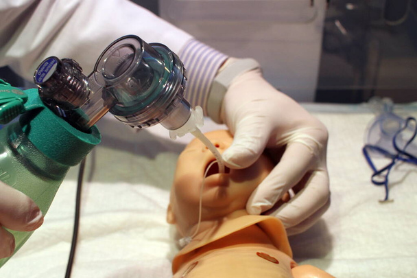 un maniquí médico para un recién nacido que le permite instalar un tubo nasogástrico y llevar a cabo la ventilación artificial utilizando una bolsa Ambu - Foto, Imagen