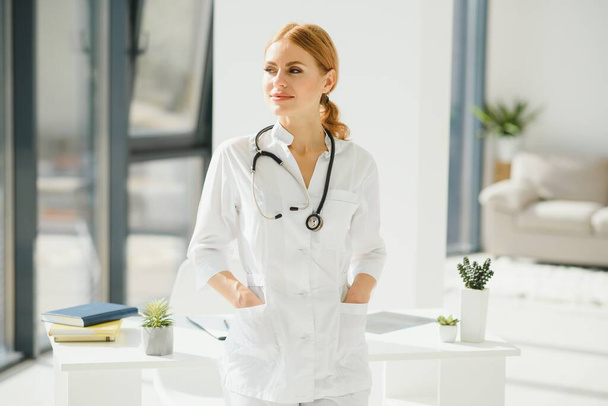 Portrait of young woman doctor with white coat standing in hospital - 写真・画像